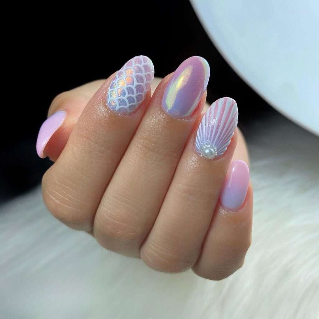 Mermaid scale nails are a whimsical, ocean-inspired manicure trend that mimics the overlapping, shimmering patterns of a mythical siren's tail. This aesthetic centers on iridescent, metallic, and holographic finishes in shades of seafoam green, aquamarine, and deep purple. In 2026, the trend has evolved toward "softer maximalism," featuring ultra-sheer glitter gels and refined 3D textures that feel airy and elegant. 