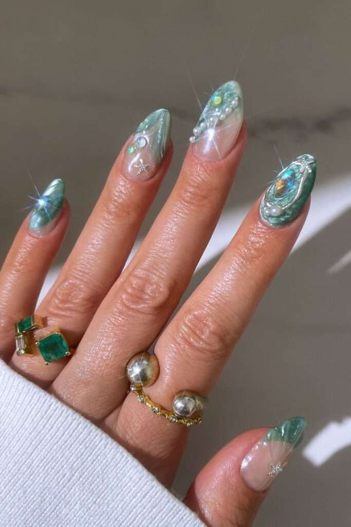 Mermaid scale nails are a whimsical, ocean-inspired manicure trend that mimics the overlapping, shimmering patterns of a mythical siren's tail. This aesthetic centers on iridescent, metallic, and holographic finishes in shades of seafoam green, aquamarine, and deep purple. In 2026, the trend has evolved toward "softer maximalism," featuring ultra-sheer glitter gels and refined 3D textures that feel airy and elegant. 