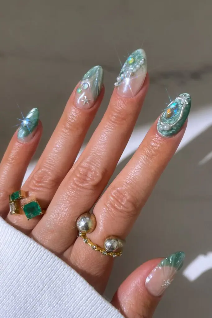 Mermaid scale nails are a whimsical, ocean-inspired manicure trend that mimics the overlapping, shimmering patterns of a mythical siren's tail. This aesthetic centers on iridescent, metallic, and holographic finishes in shades of seafoam green, aquamarine, and deep purple. In 2026, the trend has evolved toward "softer maximalism," featuring ultra-sheer glitter gels and refined 3D textures that feel airy and elegant.