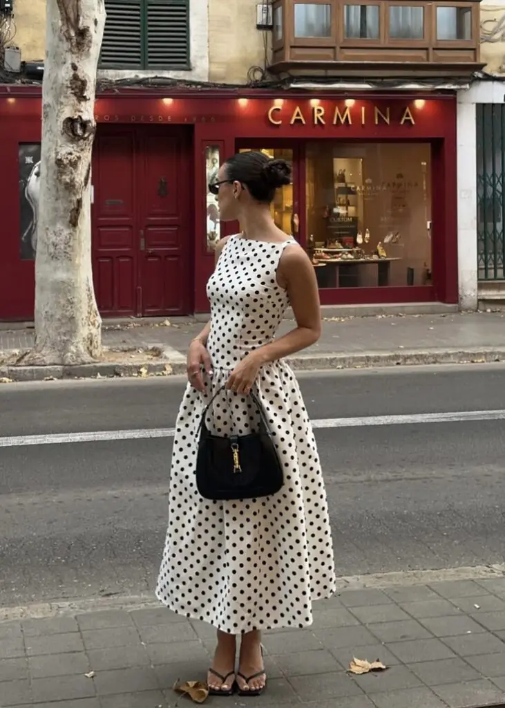 The key to wearing polka dots in Summer 2026 without looking like you raided your grandmother's closet? Scale and restraint. One dotted piece, styled against something architectural or structured. A polka-dot slip skirt with a fitted white tank and kitten mules. A dot-printed blouse worn open over a bikini top for the beach. That's the energy.