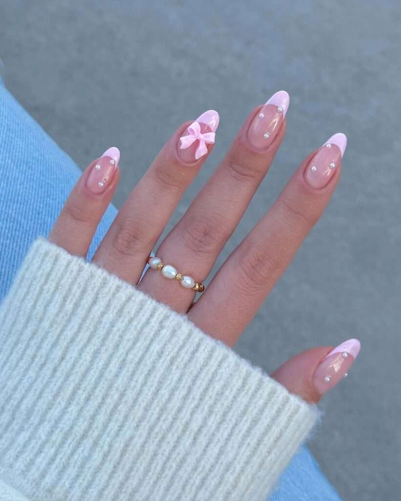 Coquette bow nails are the pinnacle of the "balletcore" and "soft girl" aesthetics, featuring delicate, hyper-feminine details like 3D ribbons, pearls, and lace patterns. This 2026 trend focuses on a "pretty in pink" palette, often utilizing sheer jelly bases to keep the look light and ethereal. 