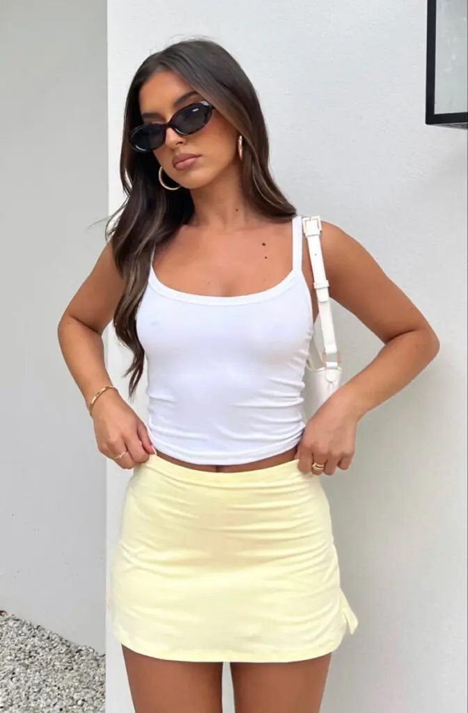 Summer 2026 is bringing back the Y2K micro mini — and we are so here for it. Pair a bright lemon yellow mini skirt with a fitted white crop top, platform sandals, and tiny tinted sunglasses.