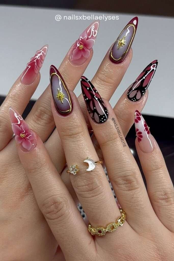 For the most dramatic fall nail art of 2026, dark fantasy nails combine burgundy, black, gold, butterfly wings, and 3D florals into a single hand. These are wearable art — perfect for autumn events, weddings, or parties.