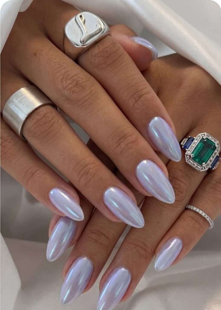 This stunning manicure features an almond-shaped cut coated in a luminous, pearlescent glazed chrome finish that radiates high-end luxury. Its frosty lavender and icy blue undertones capture natural light effortlessly, making it the perfect minimalist yet striking look for hot summer days. It provides a clean, universally flattering aesthetic that instantly elevates any outfit with an air of effortless sophistication.