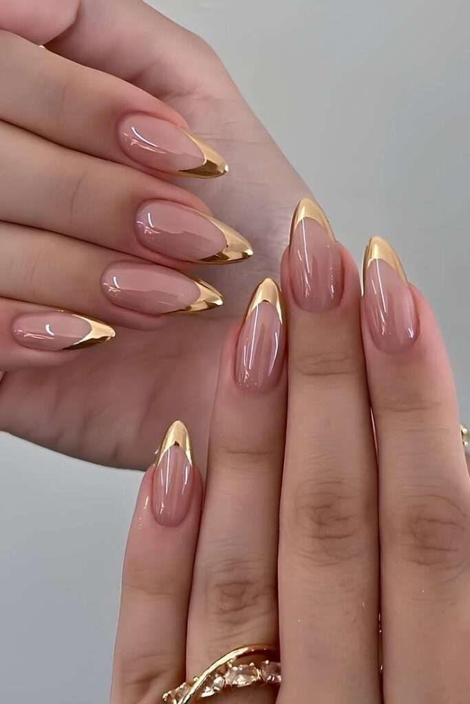 This breathtaking design breathes new life into the traditional French manicure by replacing white tips with a flawless, mirror-shine metallic gold lacquer. Set against a flawless, sheer neutral base that matches the skin tone, the crisp, gilded arches mimic fine jewelry contouring the fingertips.