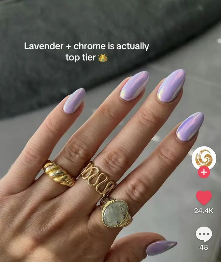 The perfectly sculpted almond nails catch the July sunlight from every angle, reflecting subtle pink and icy blue undertones. It offers a fresh, clean-girl alternative to basic neutrals while maintaining an elite finish that feels incredibly curated and fashion-forward. This captivating look redefines summer pastels by layering an iridescent glaze over a dreamy lavender base for a futuristic, pearlescent glow.