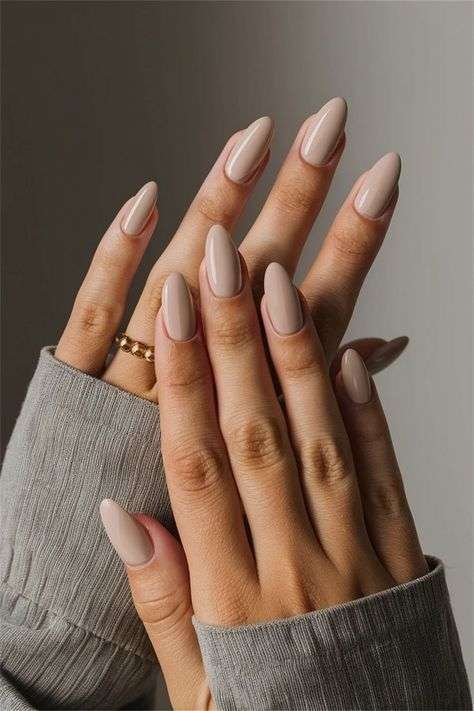 Embodying effortless sophistication, this look features mid-length almond nails coated in a rich, glossy taupe that radiates quiet luxury. The understated neutral shade offers a universally flattering finish that seamlessly transitions from professional settings to upscale summer evenings. It serves as the ultimate "clean girl" aesthetic anchor, proving that minimalist manicures can make the most expensive statement.