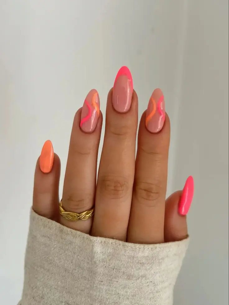 Inject high-energy luxury into your summer curation with this striking mix of neon pink French tips, solid coral accents, and fluid, multi-toned swirl art. The flawless almond shaping keeps the electric color palette feeling grounded and sophisticated, proving that vibrant neons can look incredibly chic when executed with precision. It is the ultimate poolside statement set for July, offering an upscale twist on classic festival-season aesthetics.