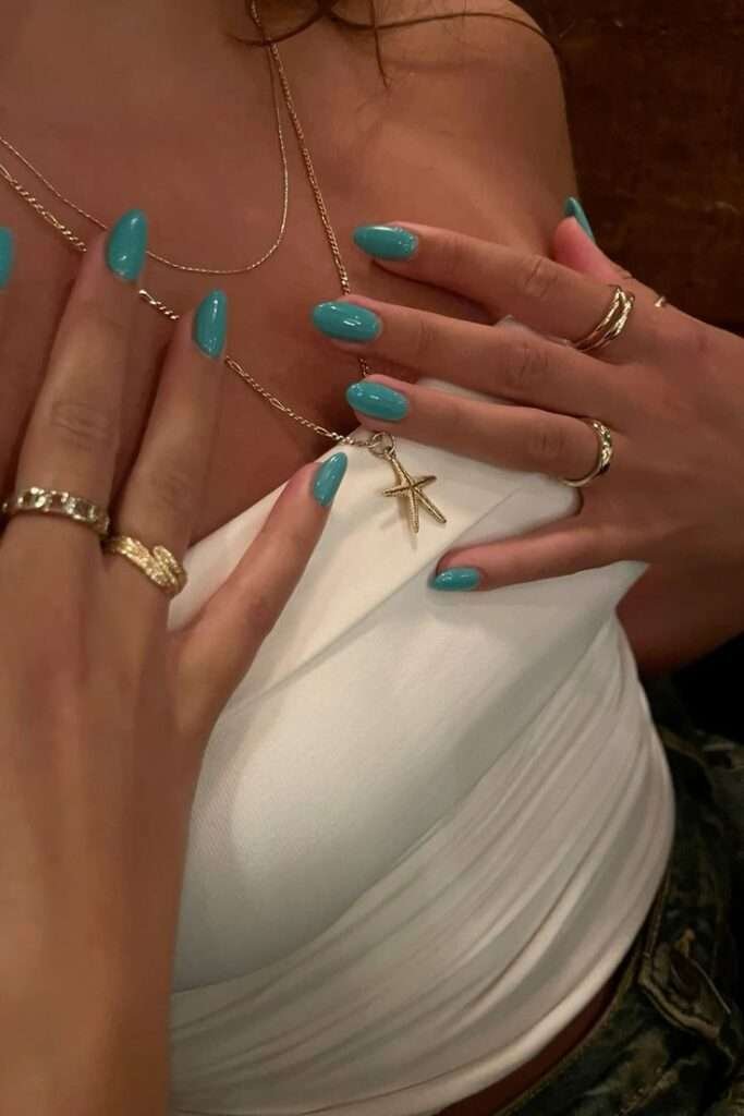 The smooth, cream-like finish catches the dim evening light perfectly, proving that a solid, bold color can look incredibly expensive when executed flawlessly. This vibrant look features a classic oval shape dressed in a rich, saturated turquoise hue that instantly evokes Mediterranean luxury.