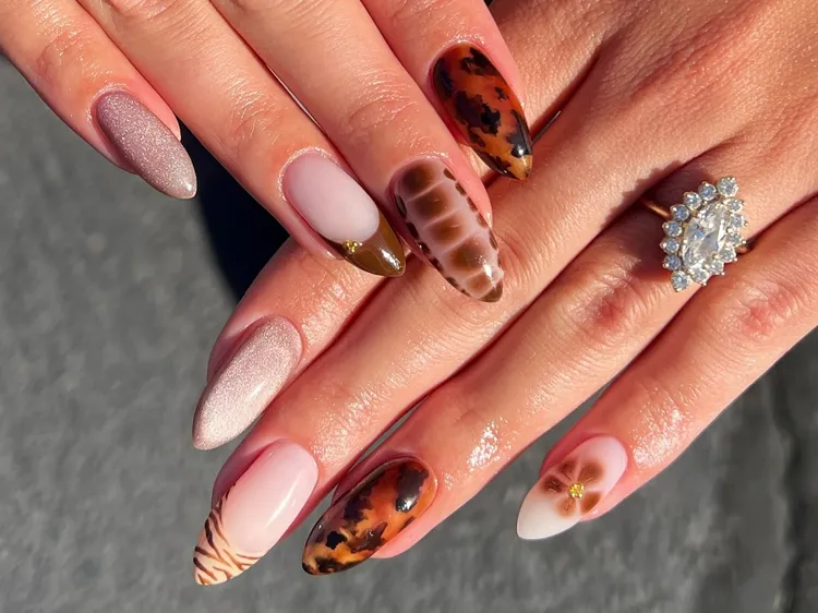 Long almond and stiletto nails mixing tortoiseshell, leopard print, striped, and shimmer designs in warm brown and nude tones.