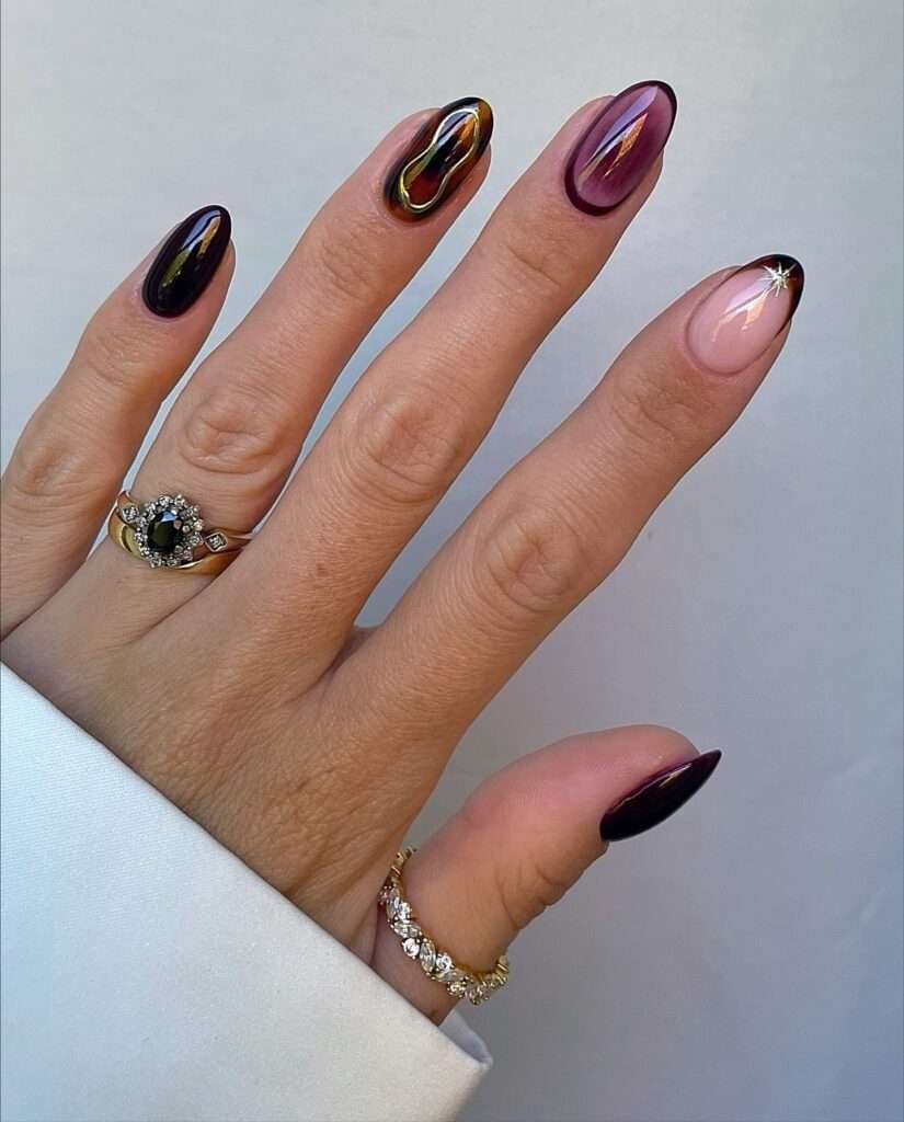 Black Cherry Chrome with Gold Flicks. Black cherry is one of my favorite October colors because it can look almost black in the shade and turn into wine-red glass in the light. Add a molten gold flick on a few nails and the manicure becomes instantly dressed up. This is a strong choice for dinners, weddings, and those first evening events of the season.