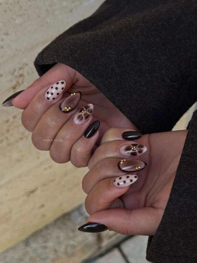 Cocoa Sweater Tortoiseshell. This manicure feels like pulling on your favorite oversized sweater. Cocoa, caramel, and tortoiseshell are layered across the nails, then finished with small raised details that make the set feel tactile and special. It is a beautiful fall nail design for short-to-medium almond shapes, especially if you prefer warmth over high contrast.
