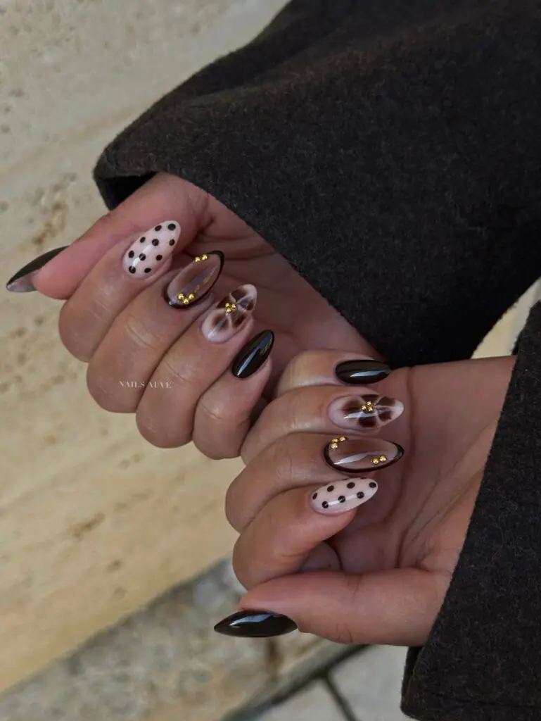 Cocoa Sweater Tortoiseshell. This manicure feels like pulling on your favorite oversized sweater. Cocoa, caramel, and tortoiseshell are layered across the nails, then finished with small raised details that make the set feel tactile and special. It is a beautiful fall nail design for short-to-medium almond shapes, especially if you prefer warmth over high contrast.