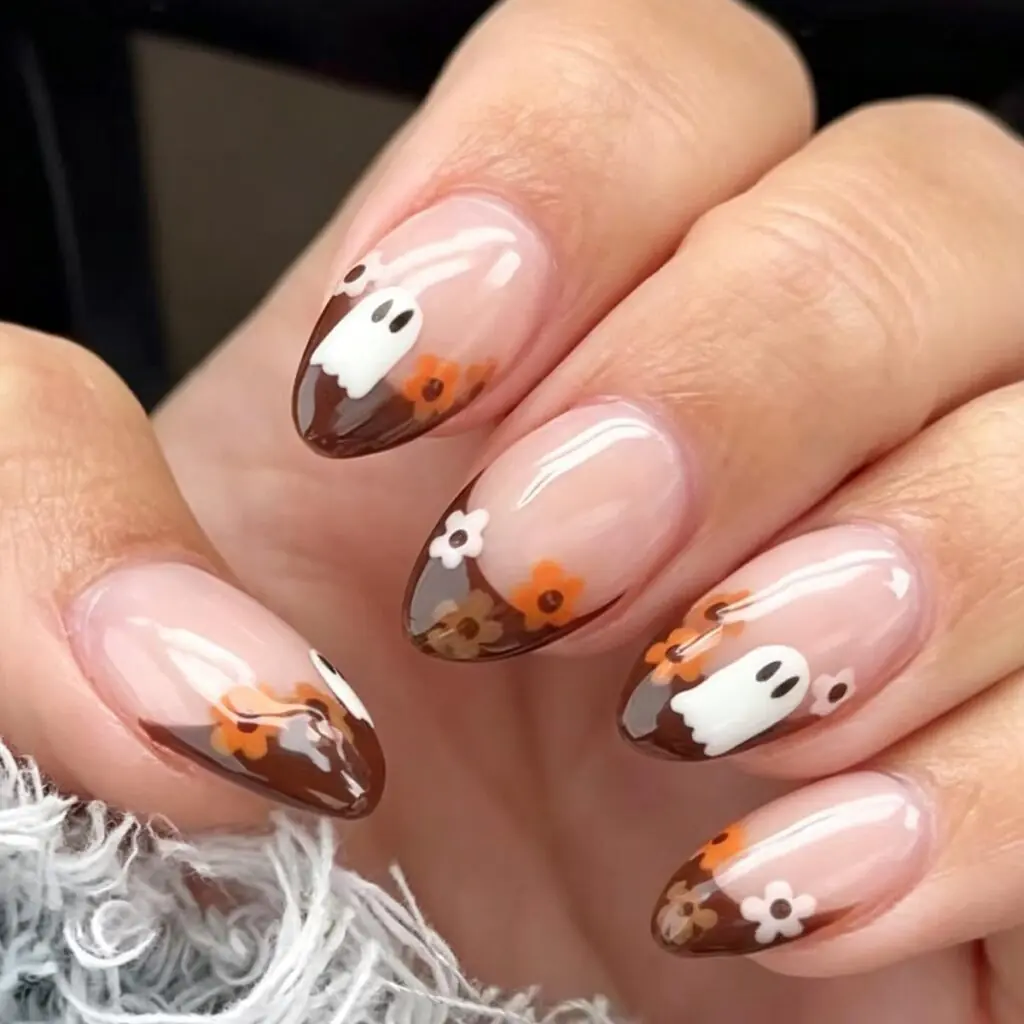 This is Halloween with a soft vintage filter. Chocolate French tips frame the blush base, and tiny white ghosts mingle with warm orange flower details. It feels a little spooky, a little sweet, and will still look lovely when October turns into November.