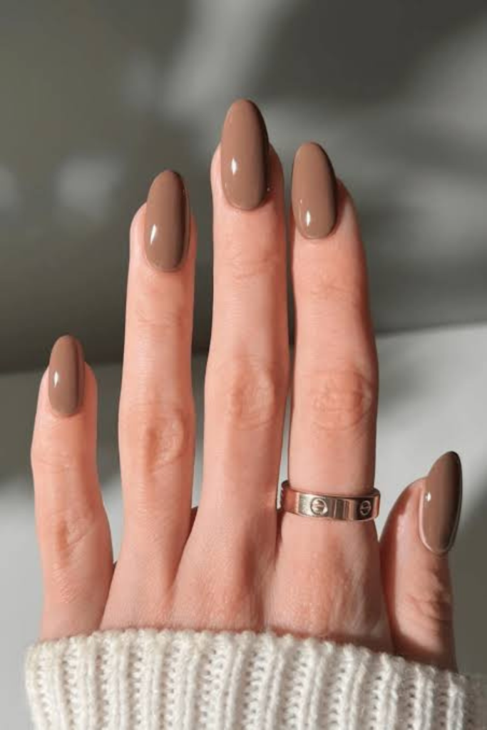 Mocha mousse nails bring a softer, creamier side to the November color palette. If chocolate brown feels too dark and caramel seems a little too golden, mocha mousse offers a beautiful middle ground. Think warm coffee mixed with milk, with subtle beige and taupe undertones. The result is a muted brown manicure that looks refined without drawing too much attention. The color name also has a connection to the wider fashion and design world.