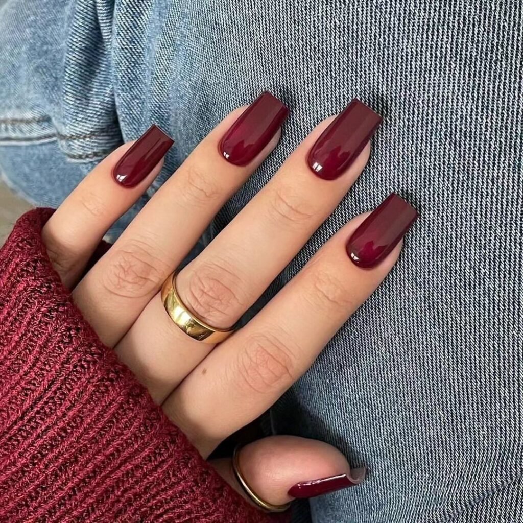 Same family, different mood. A long square shape gives oxblood a sharper, more graphic look, and the glossy finish makes the colour look almost like lacquer. Pair it with gold rings and denim, as in this set, and it feels relaxed rather than formal.