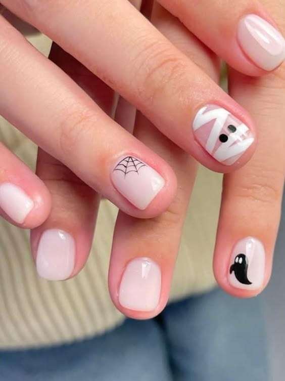 Tiny Ghosts in a Pink Night Sky Little ghosts, tiny pumpkins, and soft pink polish make this set feel like the cute side of a Halloween movie. It is sweet without being childish and looks adorable peeking from a cardigan sleeve. If your Pinterest board is full of cute Halloween nails, save this one.