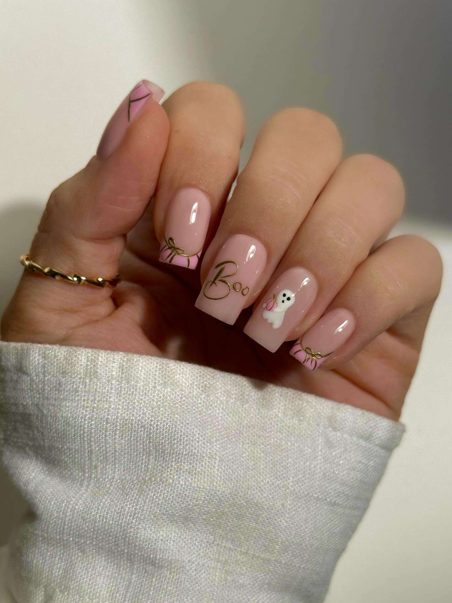 These short pink nails combine delicate gold bow details with an adorable little ghost accent.
The soft blush base keeps the manicure feminine, while the tiny ghost adds a playful Halloween touch.
Fine gold linework around the tips gives the design a chic, polished finish.
I’d choose this look when I want Halloween nails that feel cute, subtle, and girly.