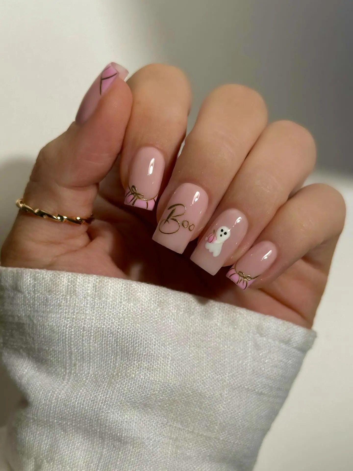 These short pink nails combine delicate gold bow details with an adorable little ghost accent.
The soft blush base keeps the manicure feminine, while the tiny ghost adds a playful Halloween touch.
Fine gold linework around the tips gives the design a chic, polished finish.
I’d choose this look when I want Halloween nails that feel cute, subtle, and girly.