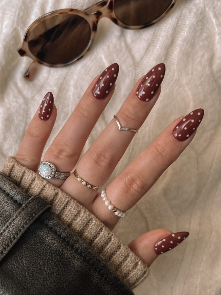 Polka dots can look sweet or retro depending on the colour behind them. On a deep chocolate base, white dots feel grown up, almost like a silk scarf print. This long almond set keeps the dots small and evenly scattered, which is what stops the design from looking busy.
